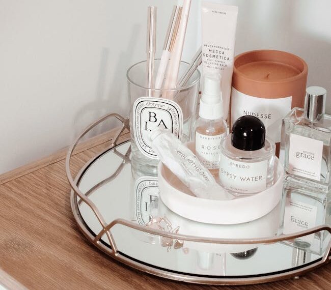 Stylish arrangement of beauty products on a wooden table with a mirror tray, creating an aesthetic display.